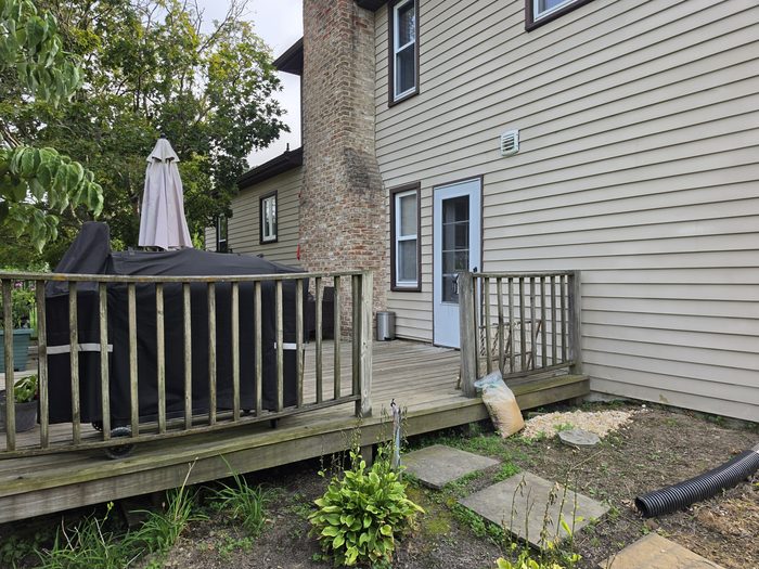 Worn wood railing and deck boards beside the back door before the rebuild — Hampden Township, PA