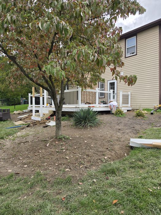 Railing and white trim wrap in progress on the new deck, viewed across the back yard — Hampden Township, PA
