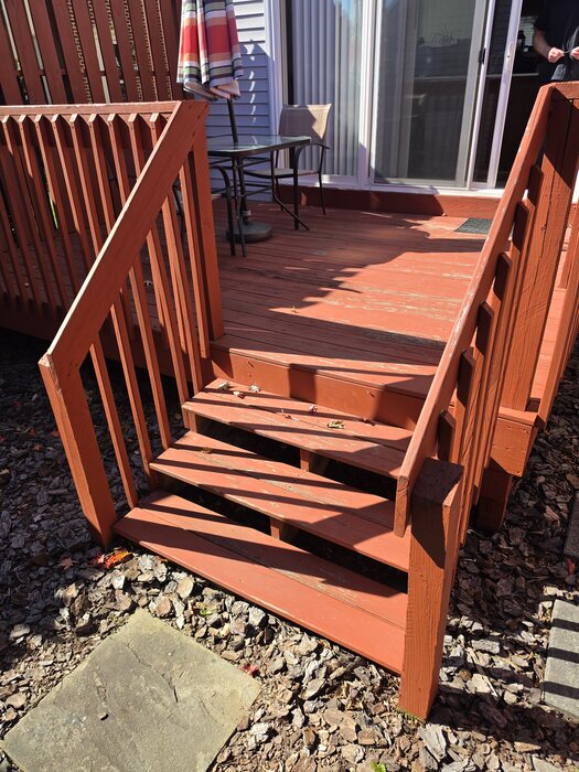 Original red-stained wood deck and stairs with a weathered wood railing before the refresh, Upper Allen Township, PA