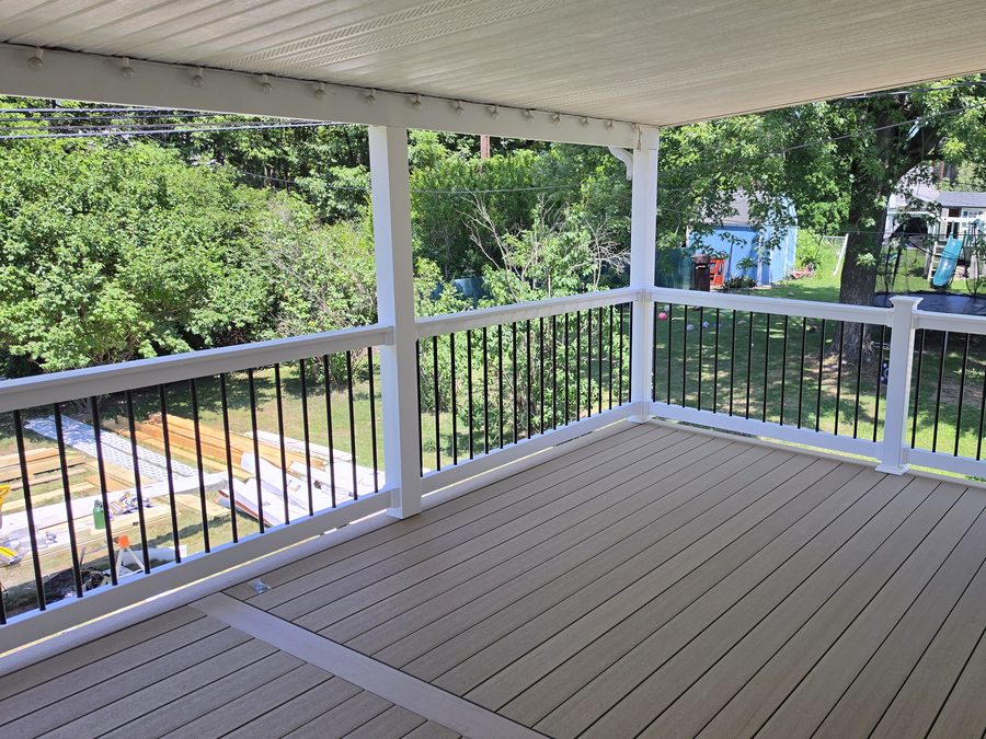 Finished second-story covered deck with grey composite decking, white vinyl railing and black aluminum balusters — Central Pennsylvania