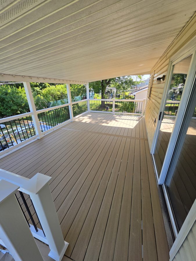 Grey composite decking running the length of the house to the sliding door, under the existing porch roof — Central Pennsylvania