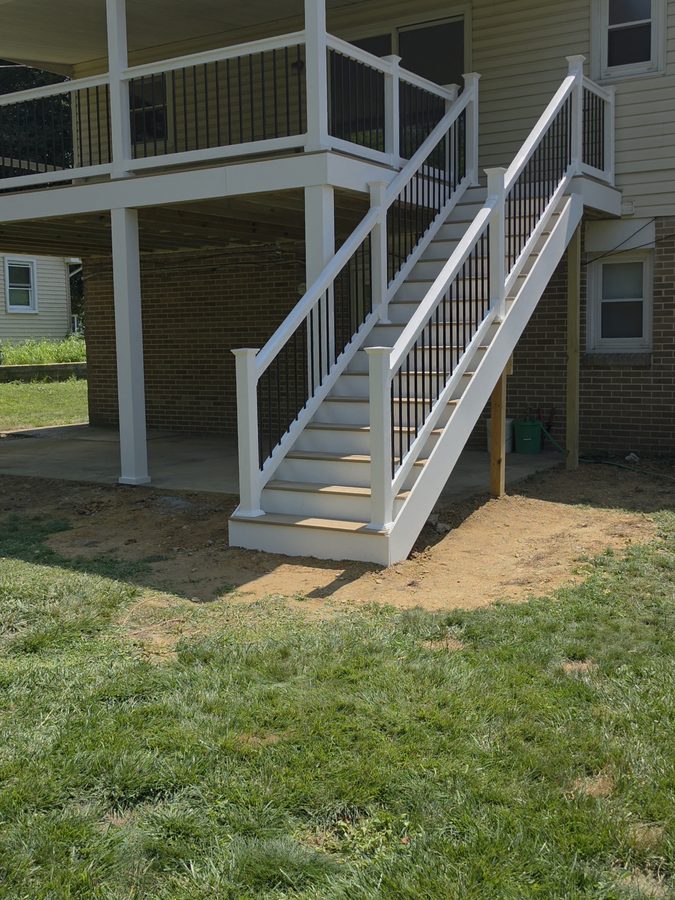 New stair run with white vinyl railing and black balusters coming off the second-story deck — Central Pennsylvania