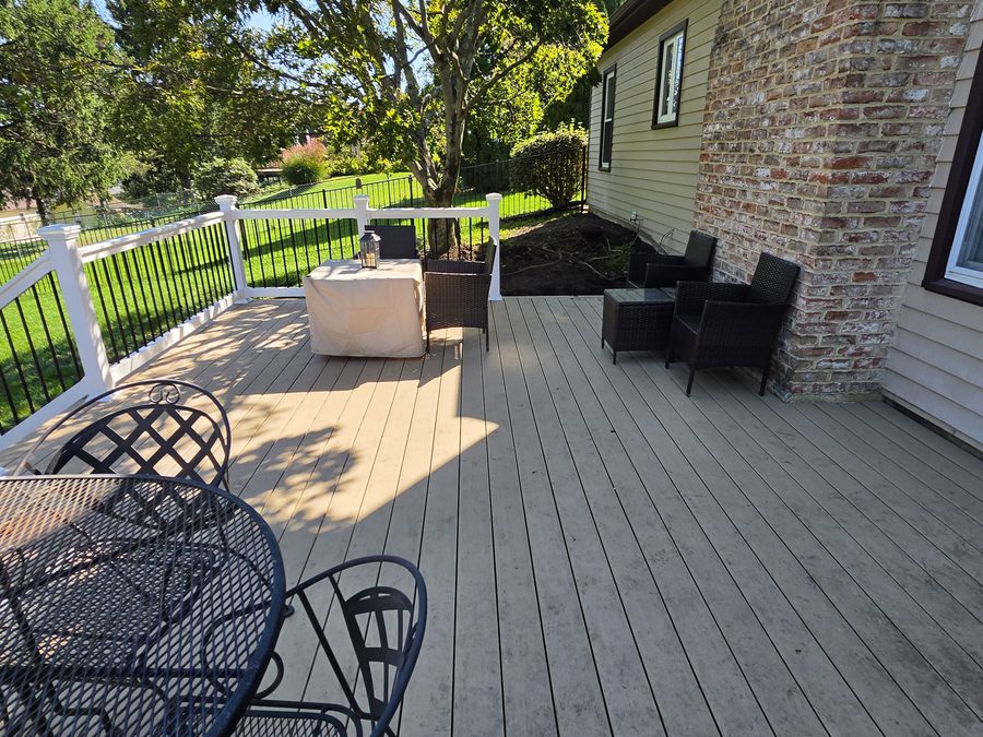 Natural White Oak composite decking running along the brick chimney, with white vinyl railing beyond — Hampden Township, PA