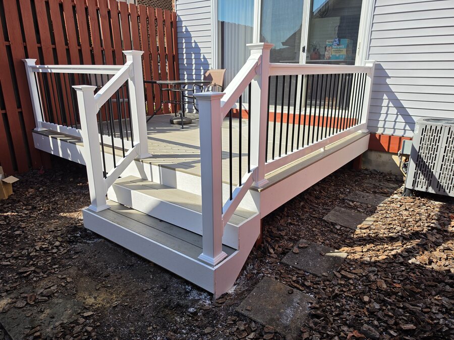 Refreshed deck with new TimberTech Weather Oak composite boards, RDI white vinyl railing with black balusters and a new stair run, Upper Allen Township, PA